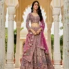 Model wearing pink gold embroidered lehenga set under royal arches, styled for wedding and festive wear