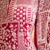 Close-up of golden zari and cut dana hand embroidery on hot pink wedding lehenga fabric